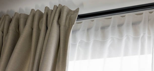 double layer day and night curtains on black rod in living room