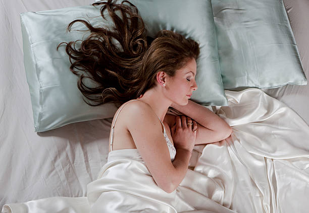 Portrait from high angle view of a cheerful young woman sleeping in her bed